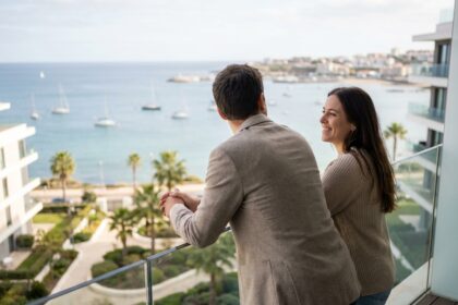 Jeune couple regardant l'océan depuis leur balcon moderne