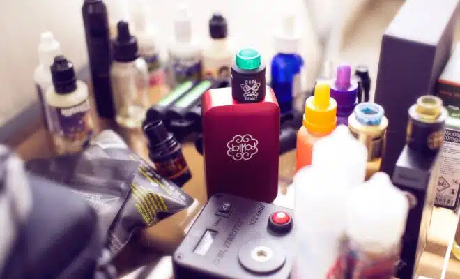 red box mod vape beside e-juice bottles