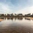 reflection of buildings and sky in body of water during daytime