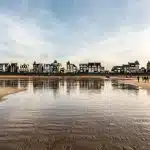 reflection of buildings and sky in body of water during daytime