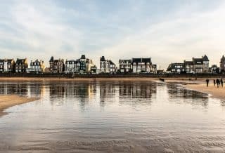 reflection of buildings and sky in body of water during daytime